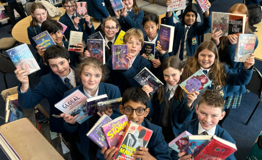 School pupils holding up books from the Read for Empathy collection.