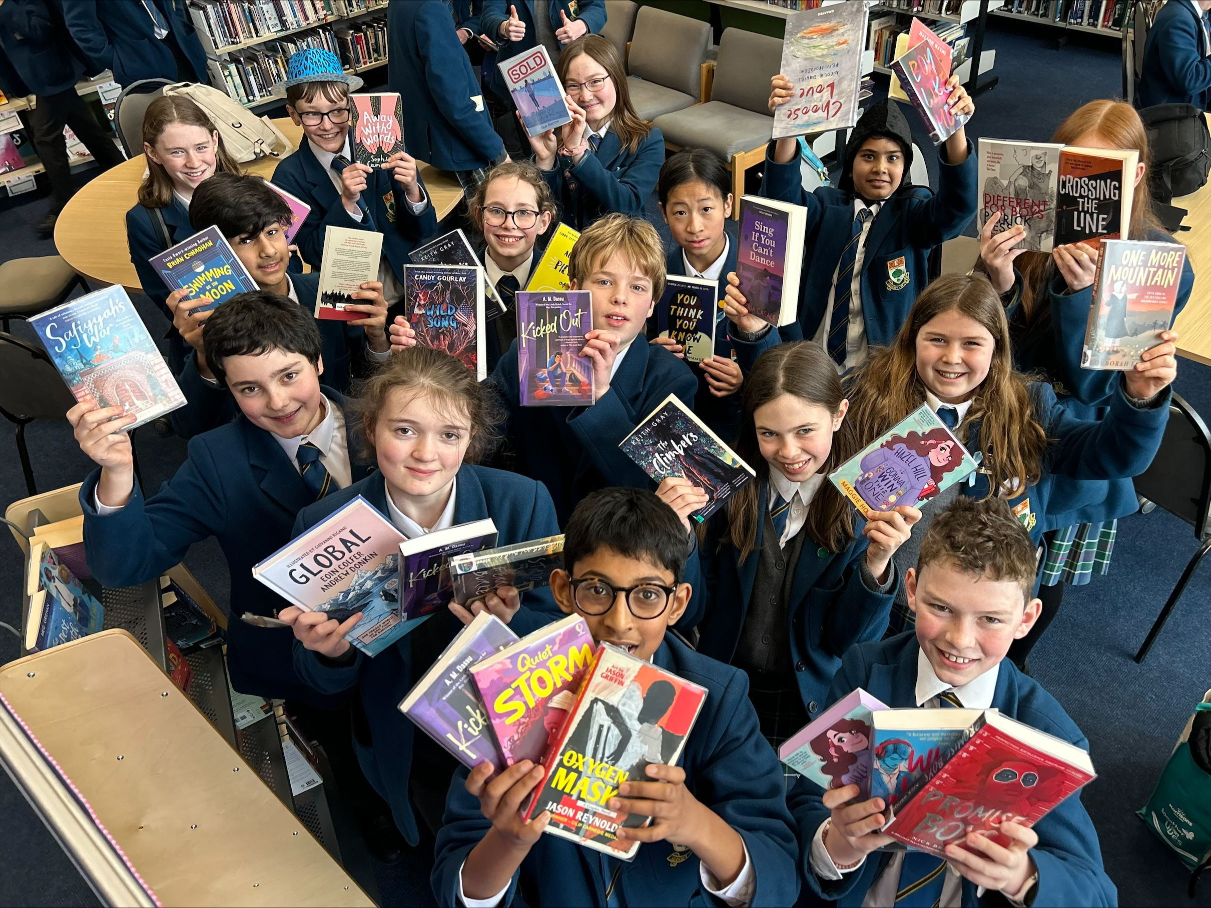 School pupils holding up books from the Read for Empathy collection.