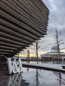 V&A Dundee building reflected in water and ships