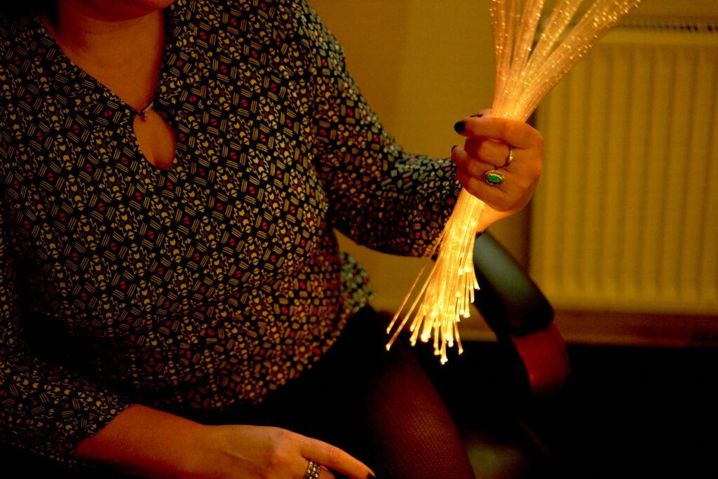 A storyteller holding light-up stems as a prop.